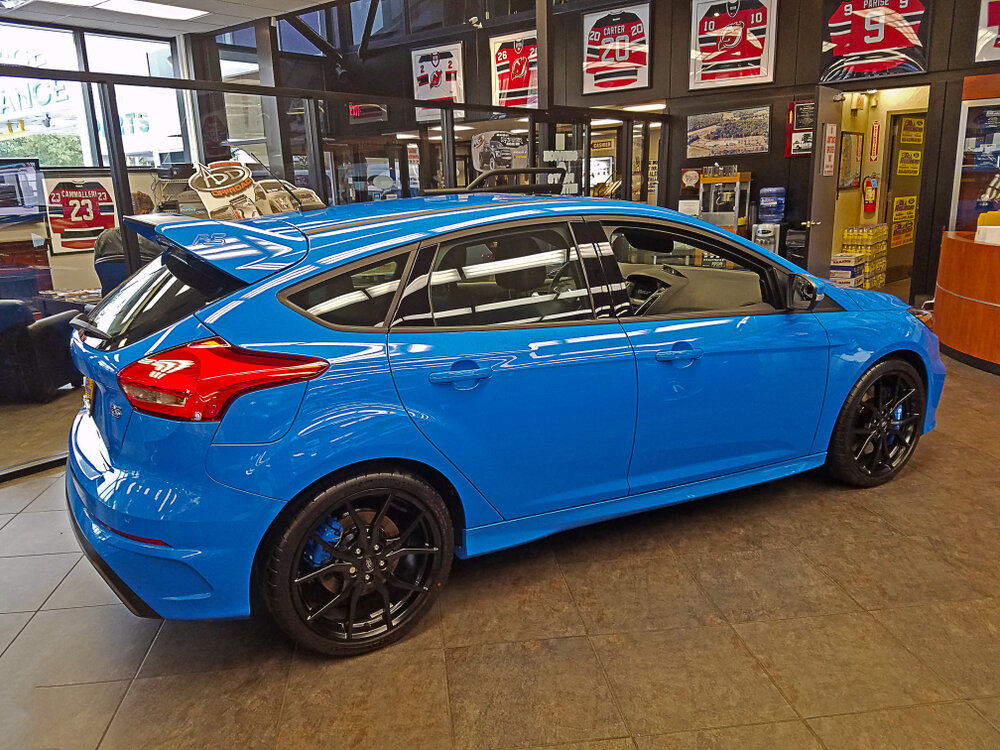 A 2017 Nitrous Blue Ford Focus RS 5 door Hatchback as seen in the Ford dealership's showroom. The RS is coupled to a 350 horsepower 2.3L EcoBoost® engine._shutterstock 1286661781