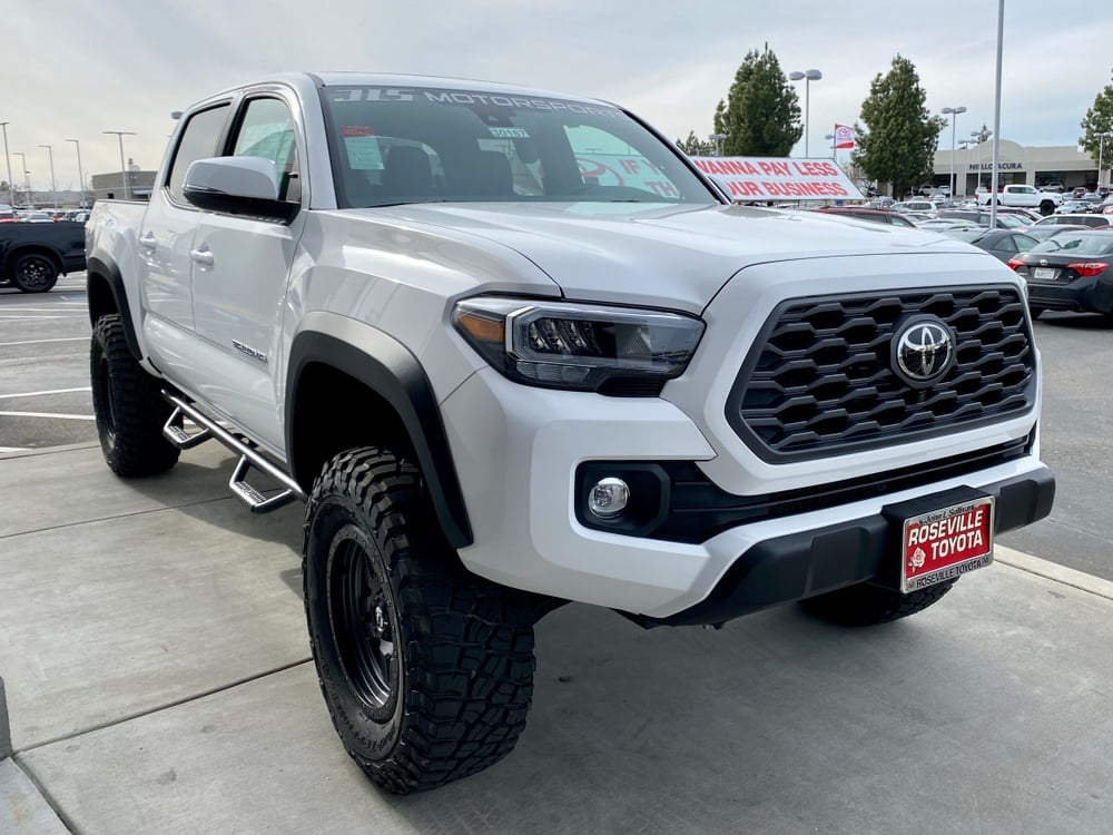 White 2020 Toyota Tacoma pick up truck on a dealership lot.