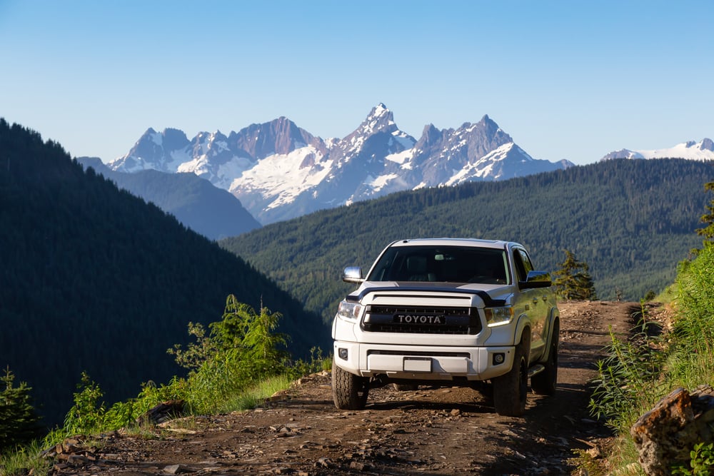 Toyota Tacoma riding on the 4x4 Offroad Trails in the mountains during a sunny summer morning.