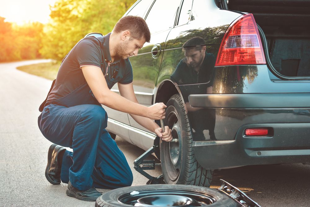 A man changing a flat tire.