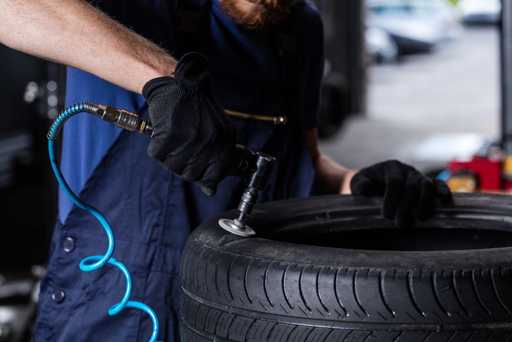 A mechanic buffs a tire during a tire repair