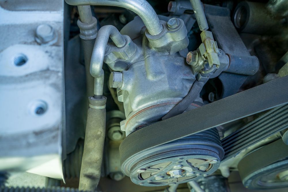 Car AC compressor with drivebelt on the pulley.