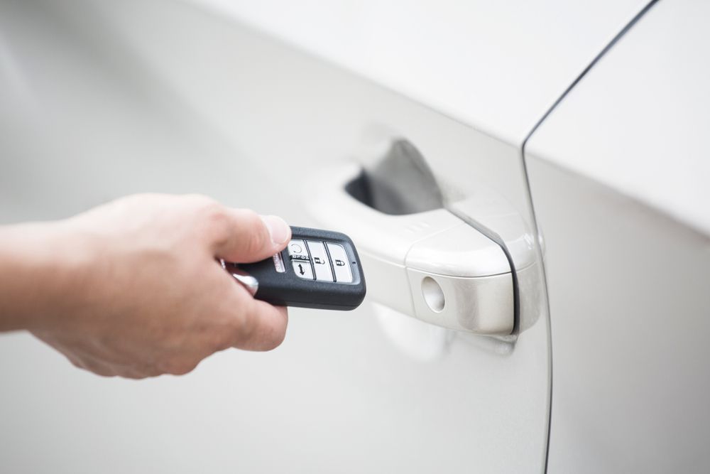 Car owner unlocking their car with their key fob.