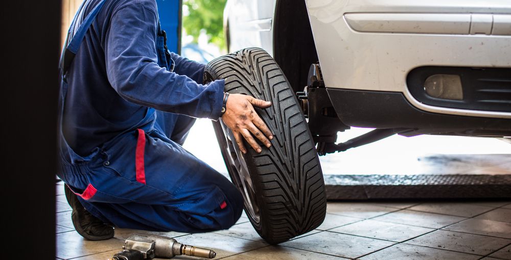 A technician changing a tire in a tire shop.