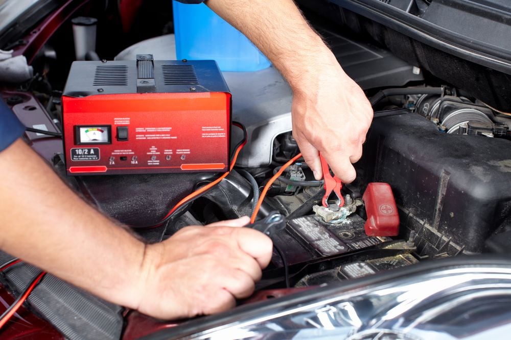 Mechanic charging a car battery