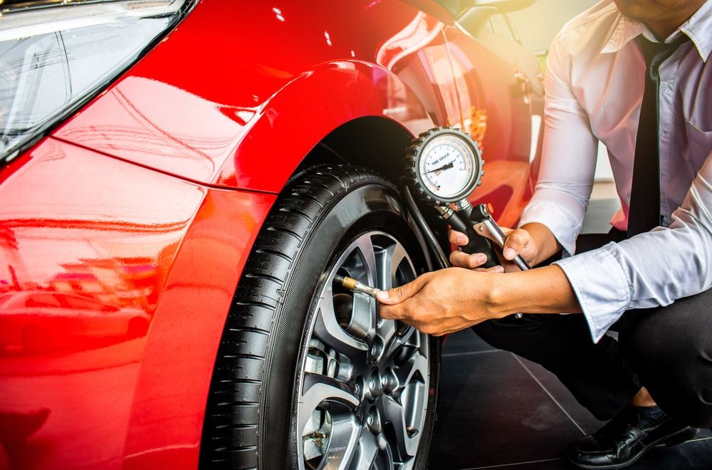 checking_tire_pressure_on_a_red_car_shutterstock_1166663170