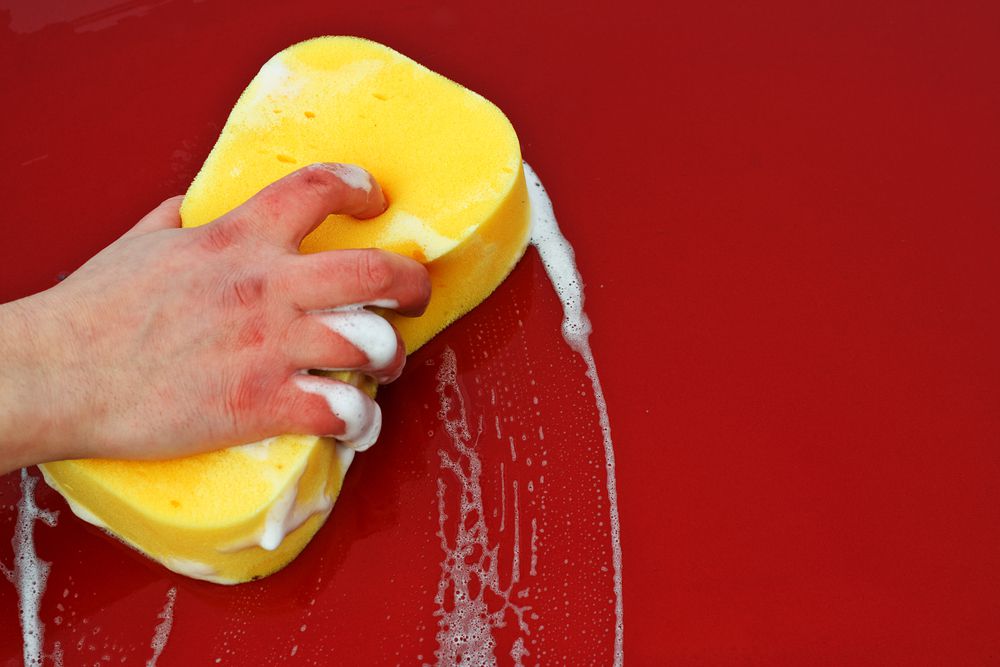 Rinsing goo gone off a car with soapy water