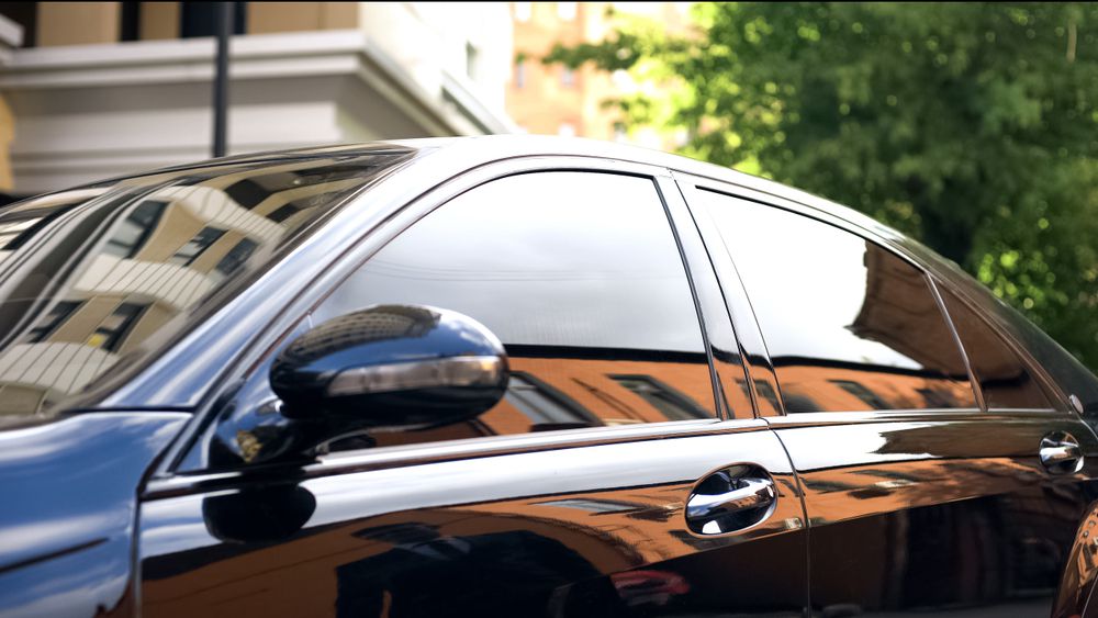 A technician applying window tint to a customer's car.