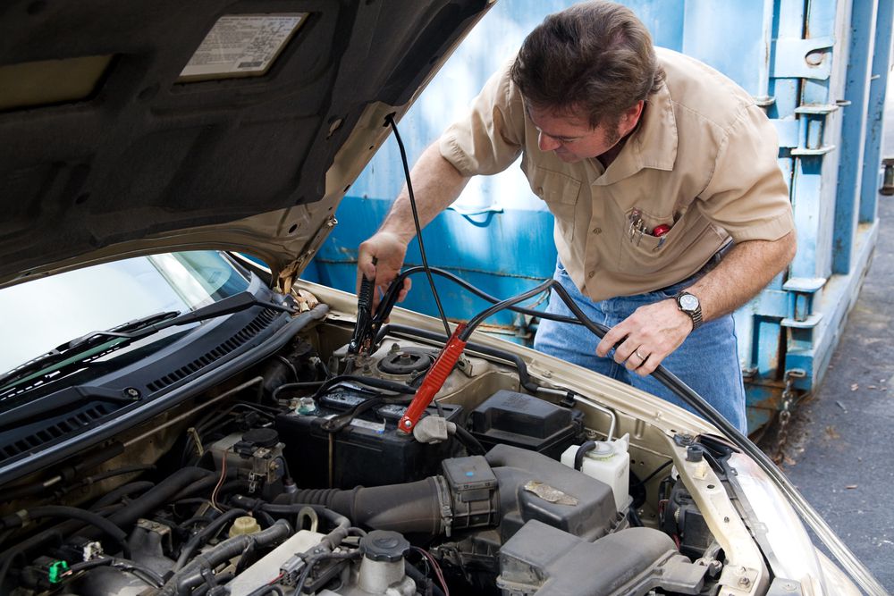 Disconnecting jumper cables from a battery.