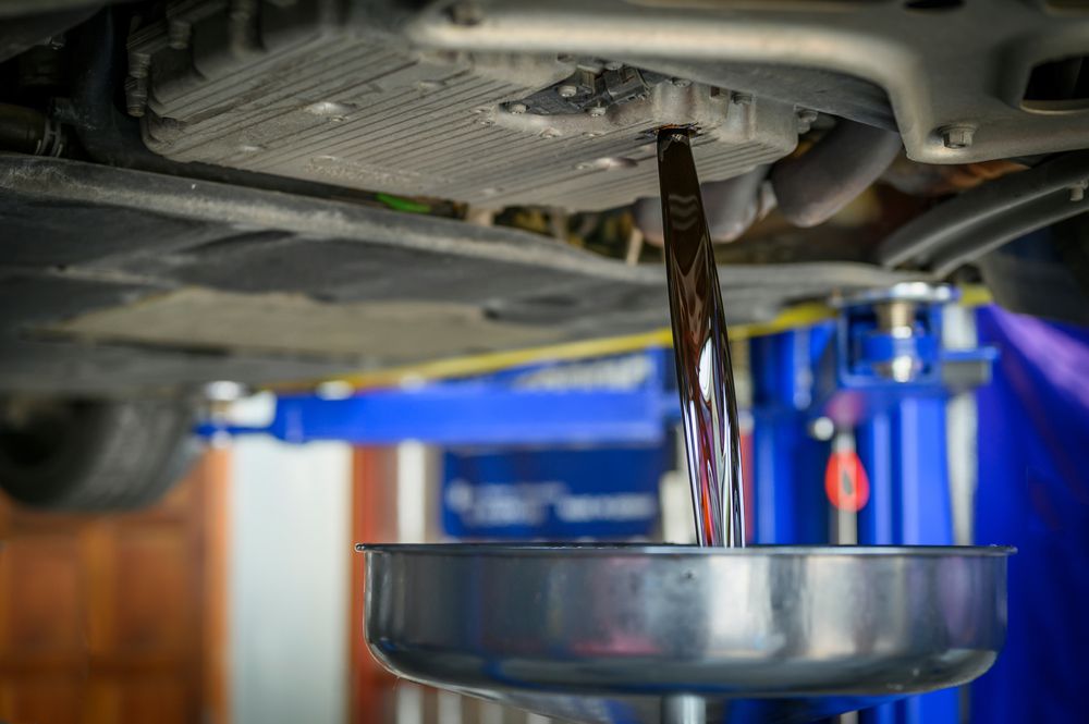 Mechanic draining old transmission fluid.