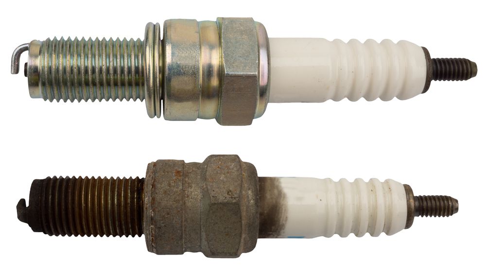 Fouled sparkplug alongside a new sparkplug.