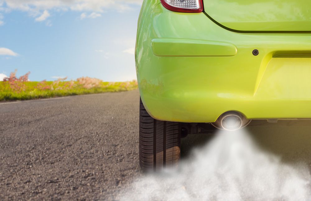 Hot exhaust exiting a car muffler.