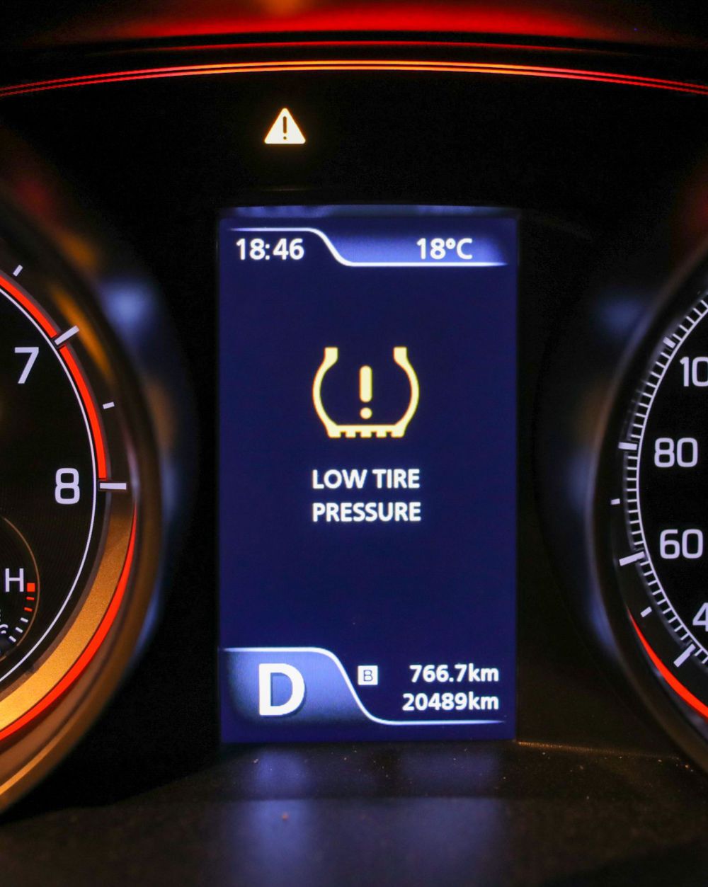 A low tire pressure warning light on the instrument cluster of a car.
