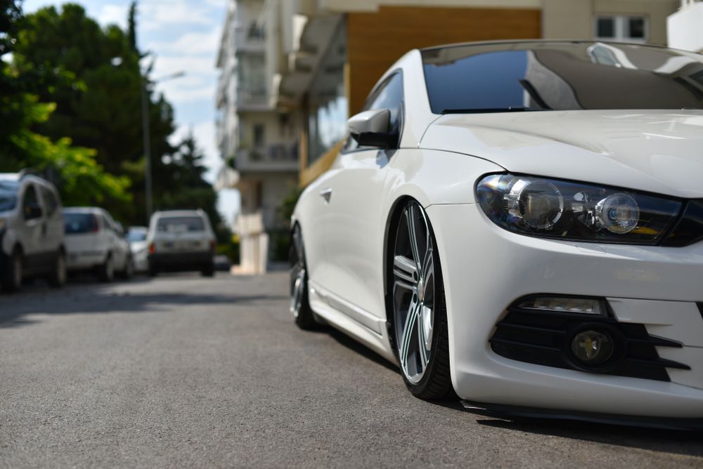 Lowered car on city street.