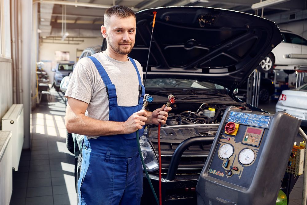 Mechanic with AC servicing machine.