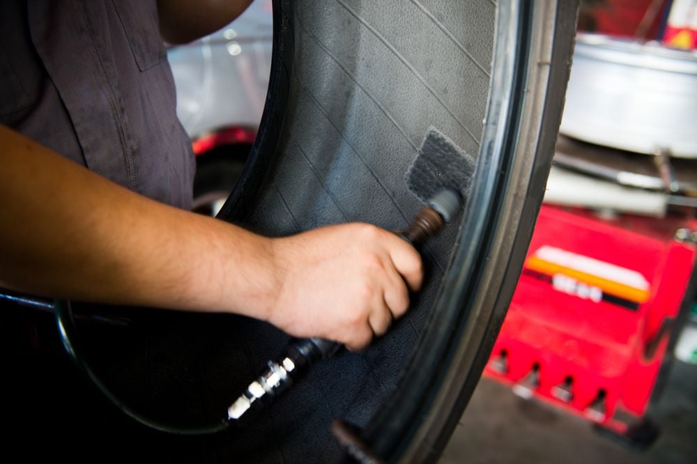 A mechanic applying a tire patch.