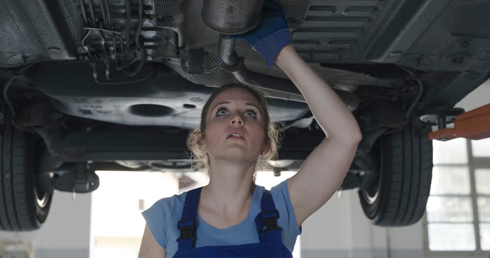 A mechanic inspecting an exhaust system.