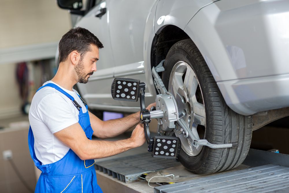 Mechanic performing wheel alignment