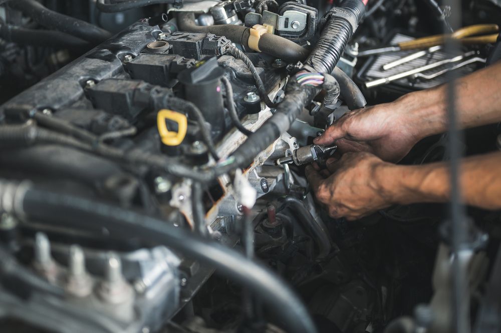 A mechanic removing a bad fuel injector.