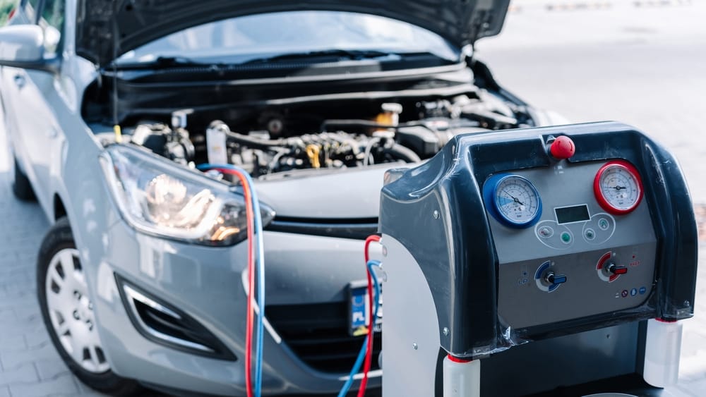 A mechanic charging a car AC system.