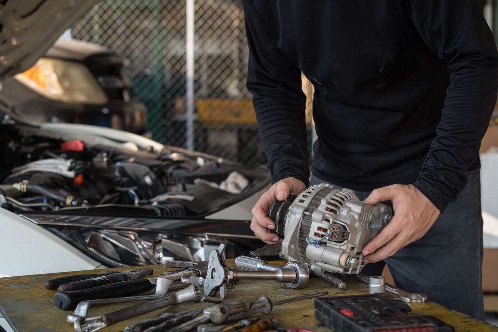 A mechanic replacing an alternator.