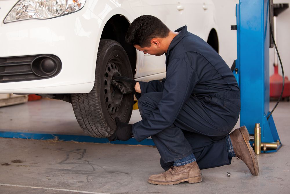 Mechanic rotating tires in a tire shop.