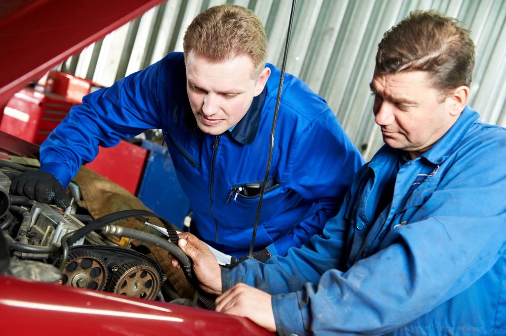 Mechanics replacing a timing belt