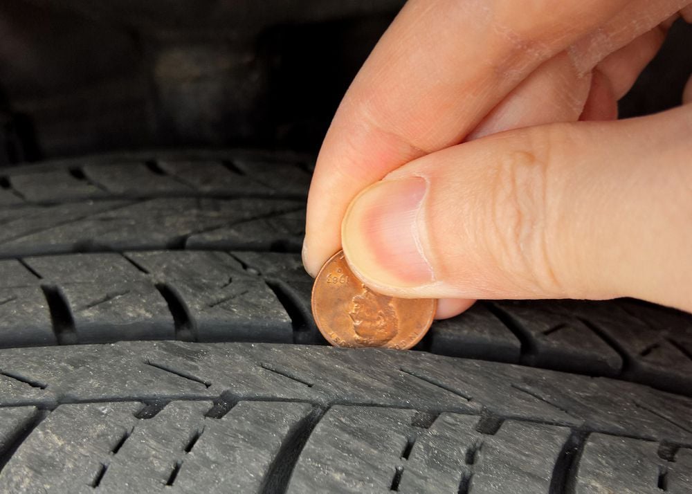Performing penny test on a tire.