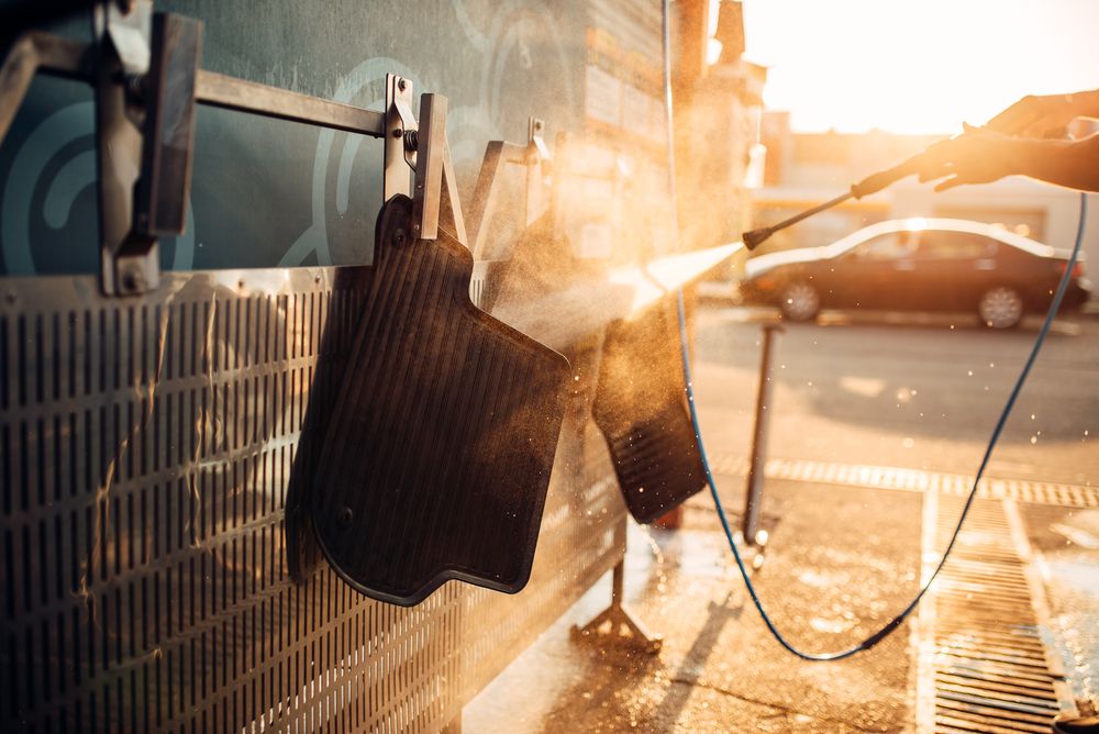 Pressure washing car mats at the carwash