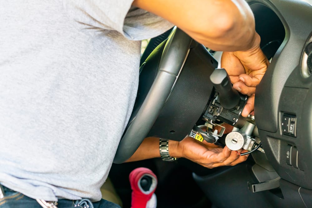 A mechanic repairing an ignition cylinder.