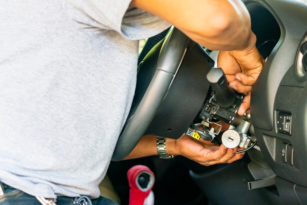 A mechanic repairing an ignition cylinder.