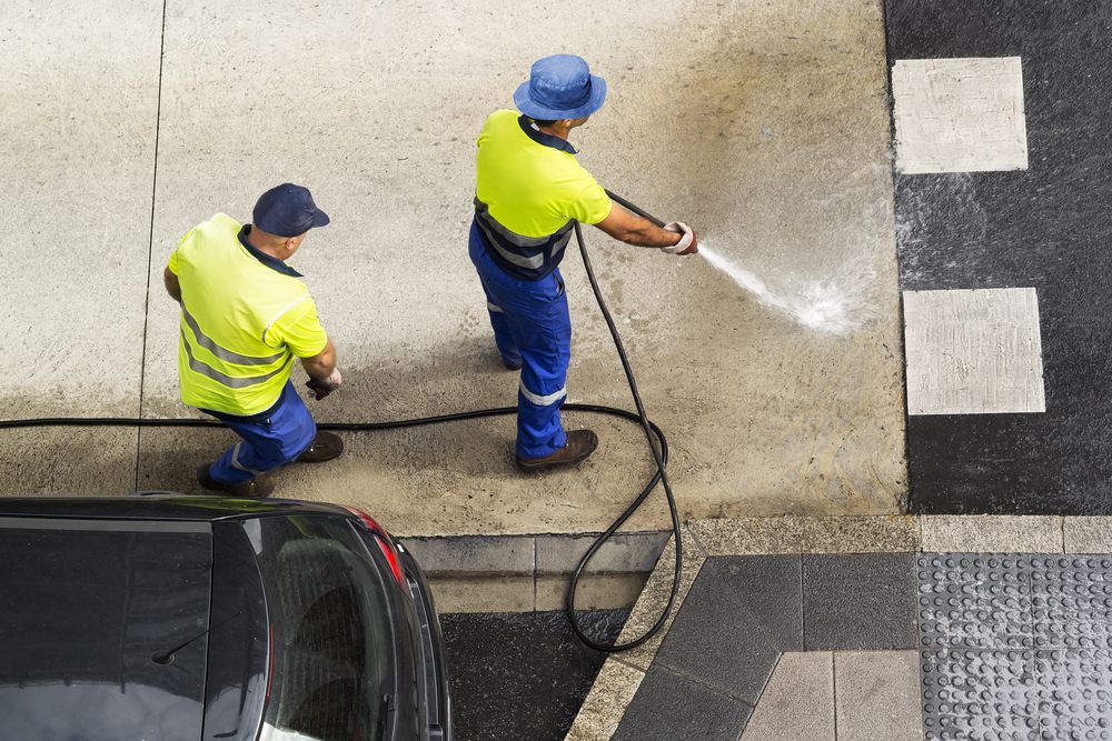 Rinsing soapy water down a storm drain.