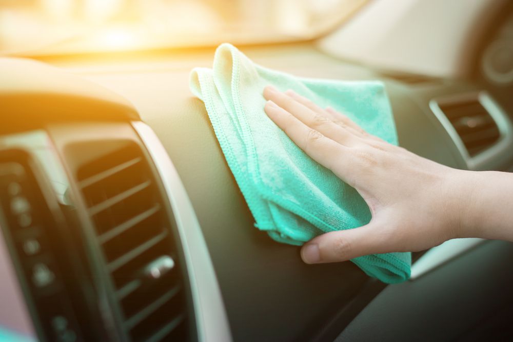 Rubbing protective chemicals into a car's dash.