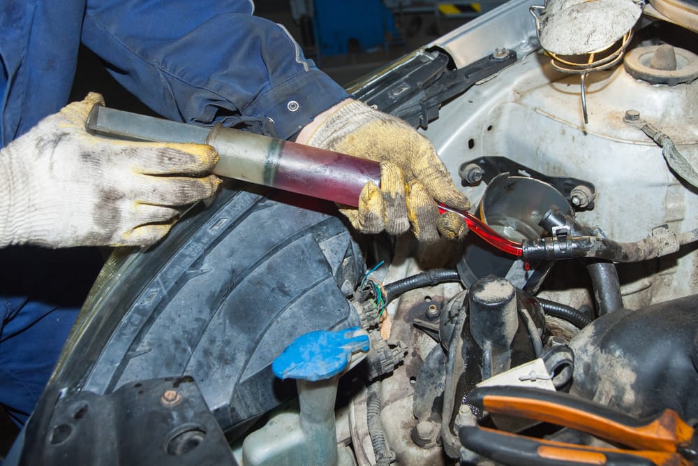 Siphoning out power steering fluid.