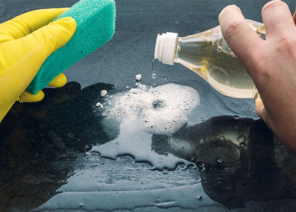 Using vinegar to clean a car hood.