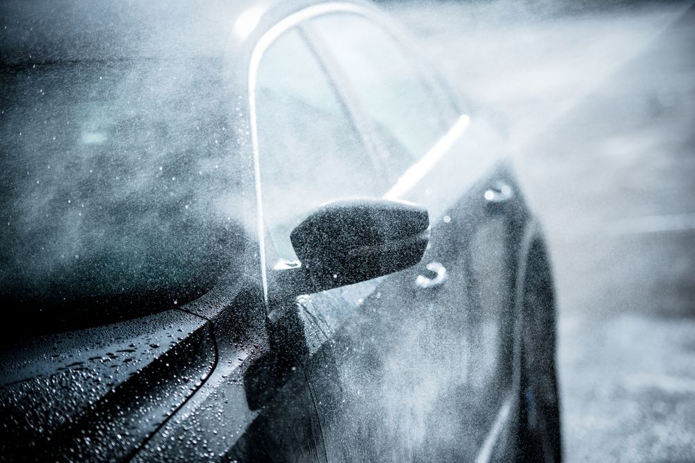 Hand washing a car with just water using a pressure washing.