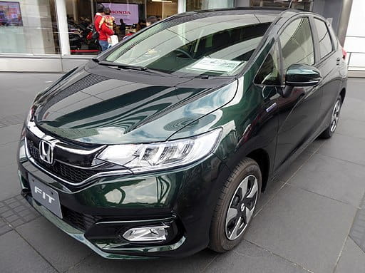 Green Honda FIT parked in front of car dealership