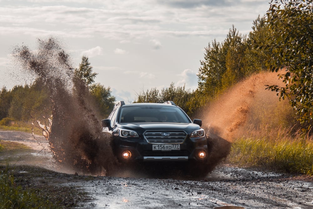 Subaru Outback Suv rides through a puddle